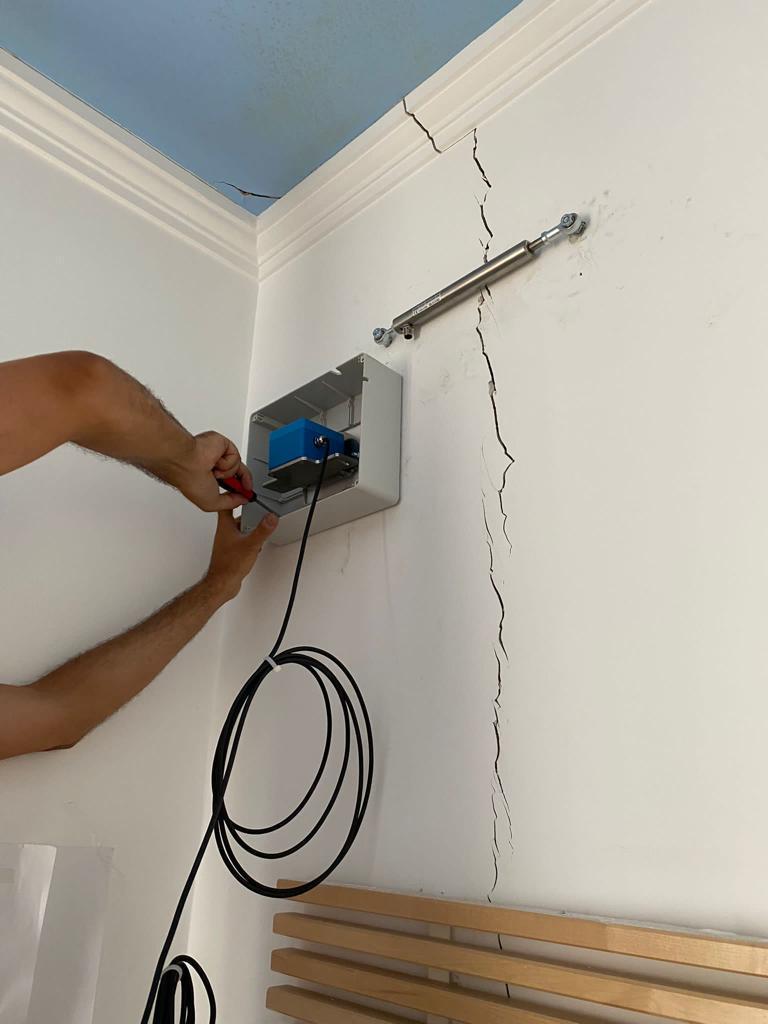 Installazione di deformometro e centralina di acquisizione su parete lesionata.